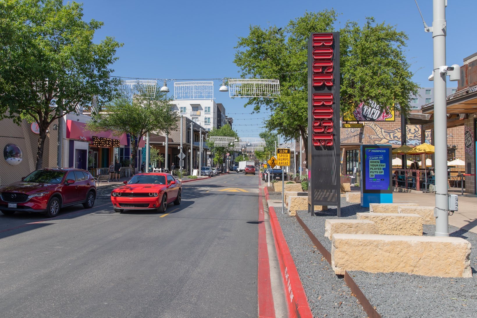 Rock Rose Ave a road with cars and attractions on each side