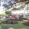 a seating area next to shops with a tree and lounge chairs